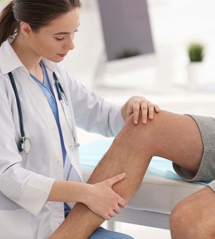 Doctor examining patients knee joint to see if they qualify for Advanced Joint Pain Relief